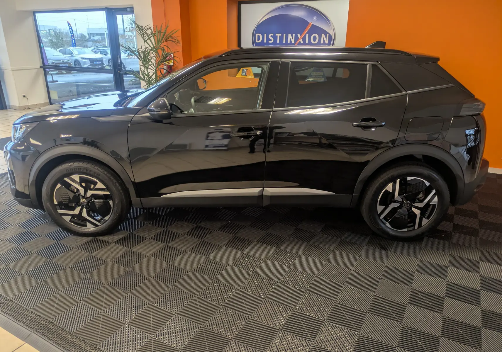 Profil côté gauche du Peugeot 2008 noir perla 2024 en finition Allure, avec jantes alliage 17'' et barres de toit brillantes.