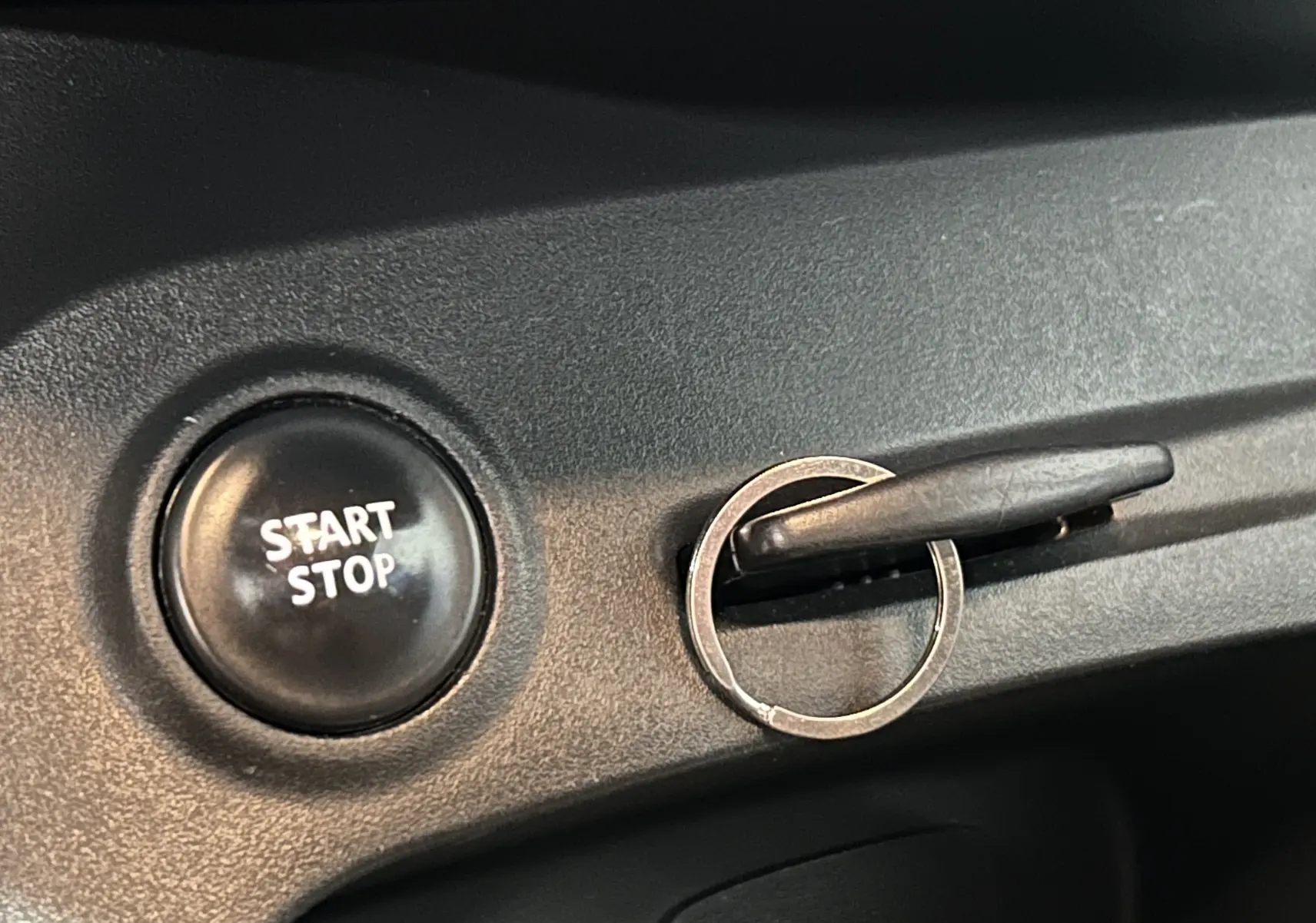 Bouton Start Stop noir avec clé insérée dans la serrure sur le tableau de bord du Renault Captur gris 2015.