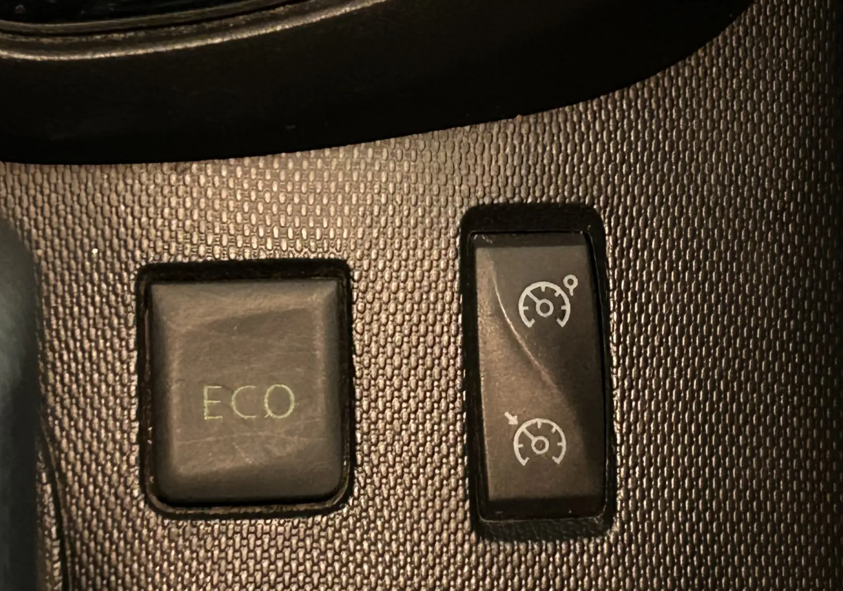 Gros plan sur les boutons ECO et régulateur de vitesse du tableau de bord du Renault Captur gris diesel 2015.