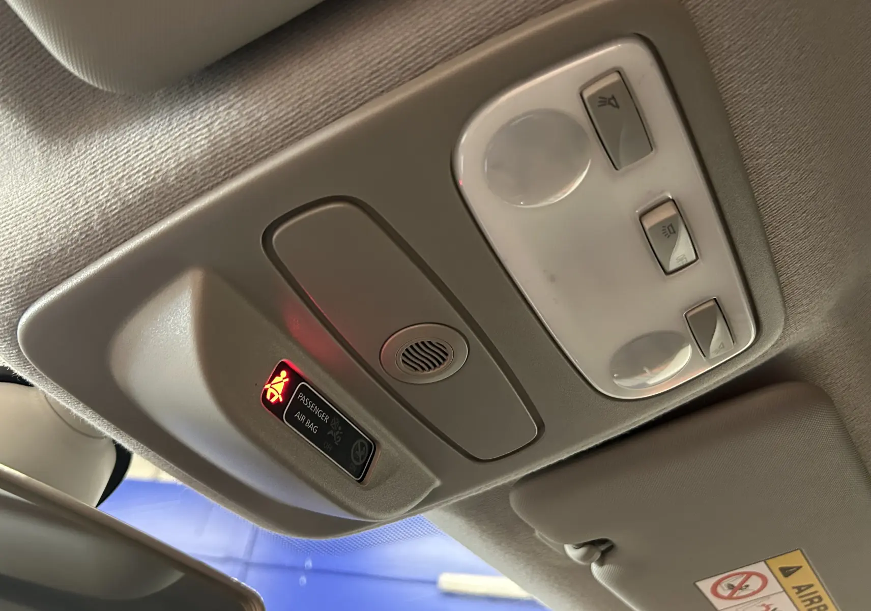 Vue intérieure du plafonnier gris du Renault Captur 2015 avec témoin airbag passager allumé.