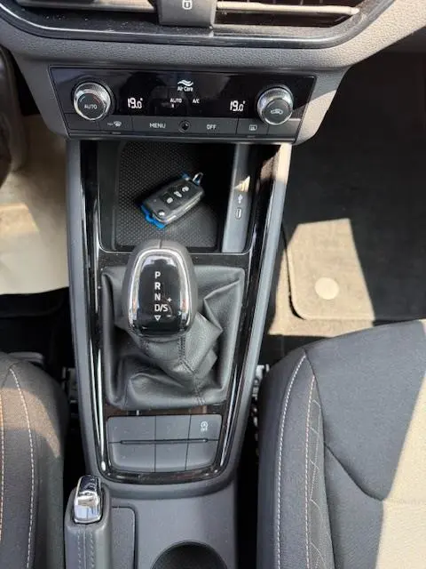 Vue plongeante sur la console centrale noire du Skoda Kamiq 2024, avec levier de vitesse automatique et clé posée.