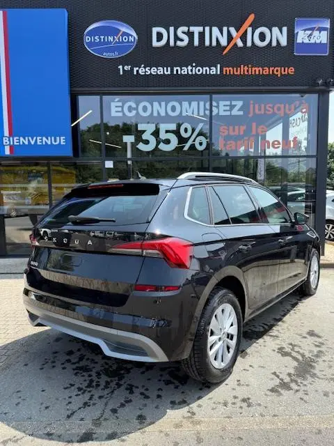 Vue 3/4 arrière droite d'un Skoda Kamiq noir 2024 garé devant une vitrine avec enseigne Distinxion.