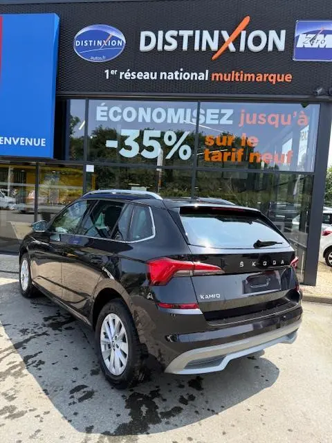 Vue 3/4 arrière droite d'un Skoda Kamiq noir 2024 garé devant une vitrine avec enseigne Distinxion.