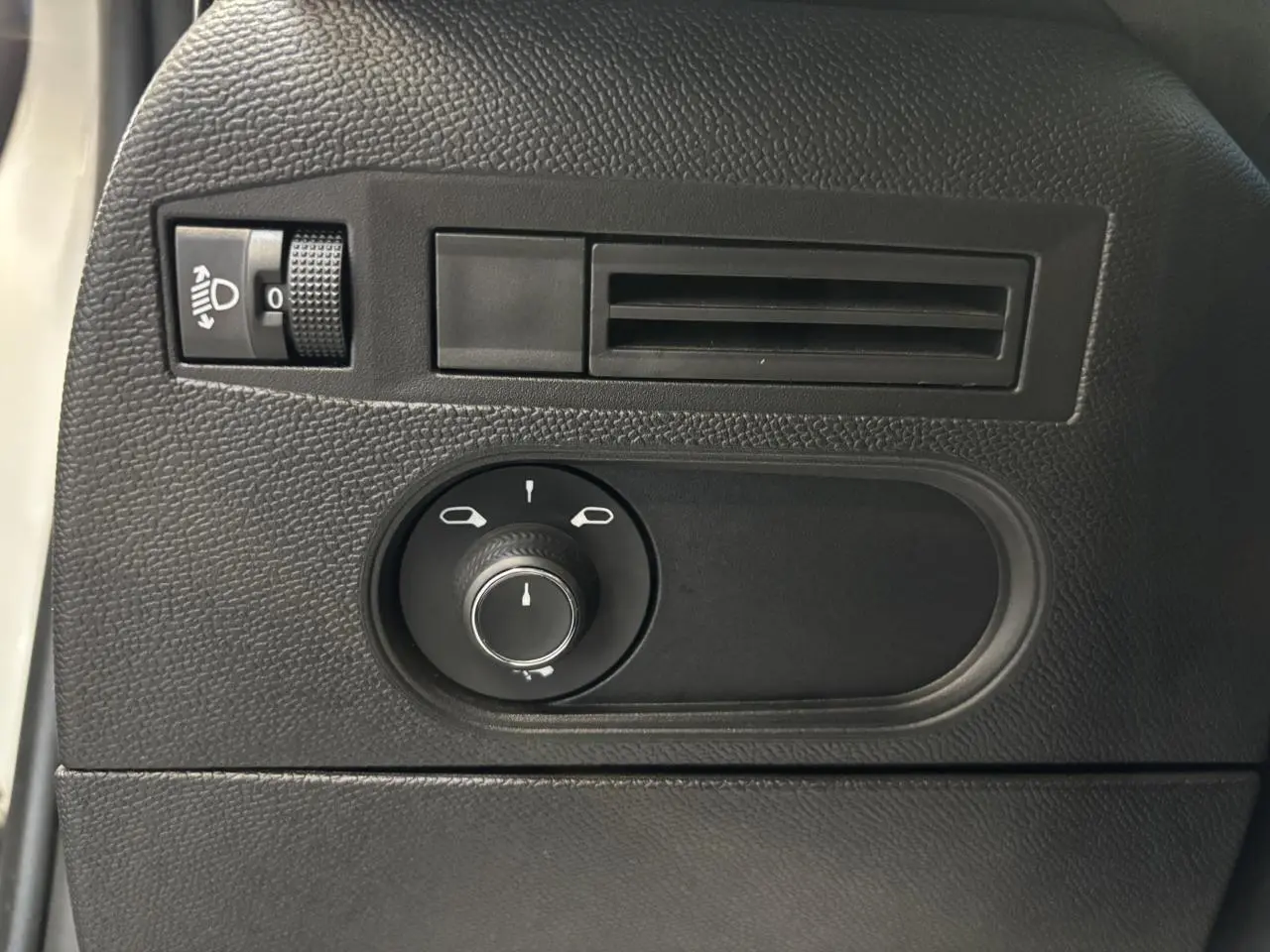 Détail du tableau de bord côté gauche du DS3 Crossback 2024, avec commande des rétroviseurs et réglage des phares.