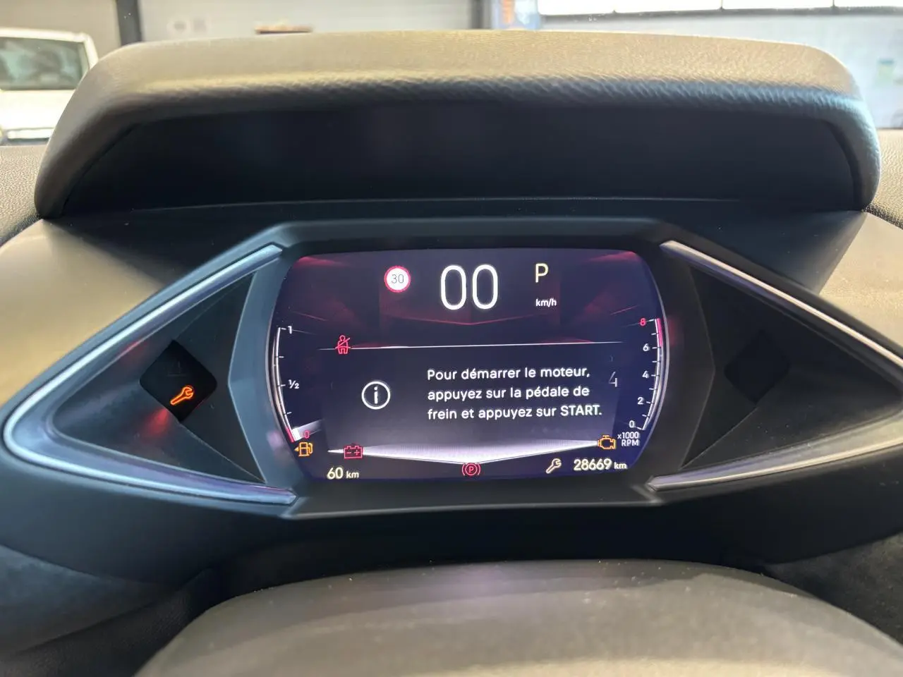 Vue rapprochée du tableau de bord numérique du DS3 Crossback 2024, affichant les instructions de démarrage et les voyants allumés.