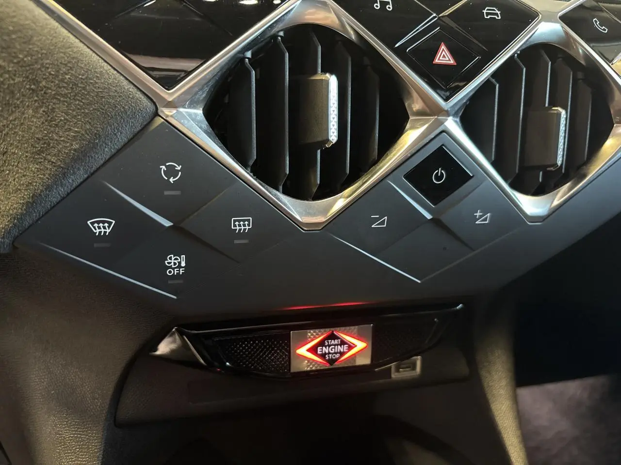 Détail du tableau de bord du DS3 Crossback 2024, avec boutons de commande et bouton start/stop illuminé, finition noire.