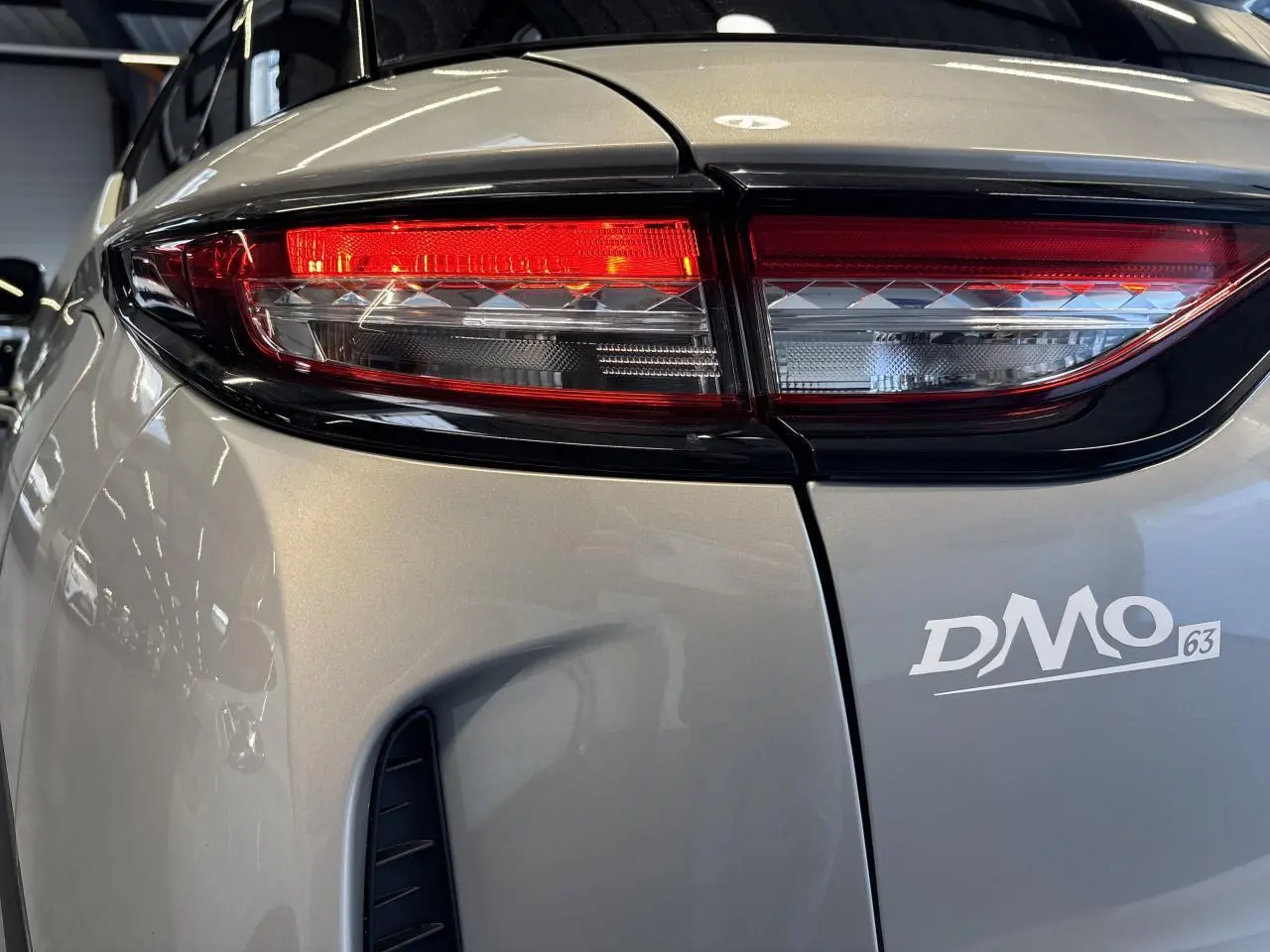 Gros plan sur le feu arrière droit du DS3 Crossback 2024 en Crystal Pearl, soulignant les détails lumineux et la carrosserie nacrée.