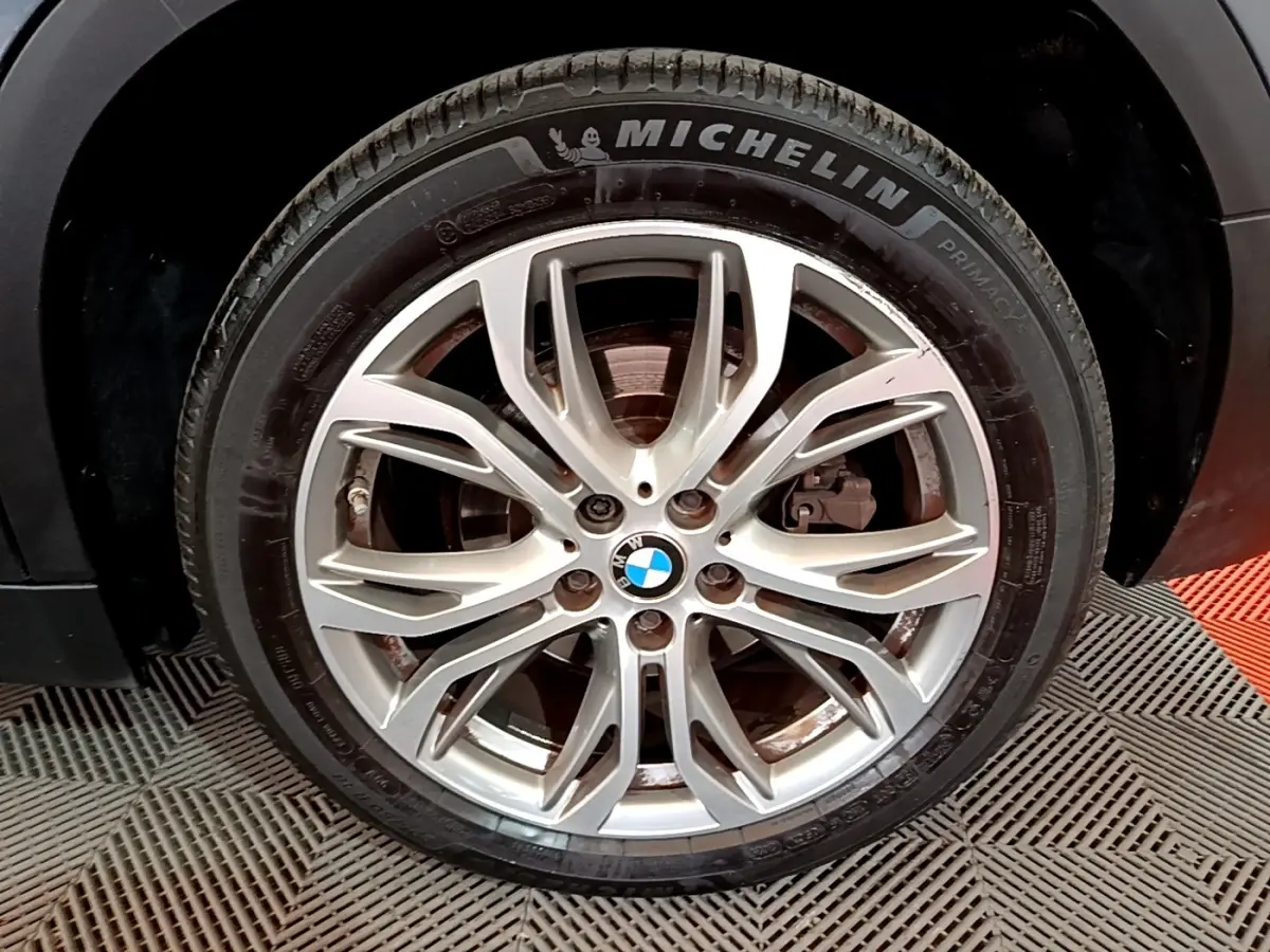 Gros plan sur la roue avant droite du BMW X2 hybride rechargeable, jante alliage argentée avec pneu Michelin.