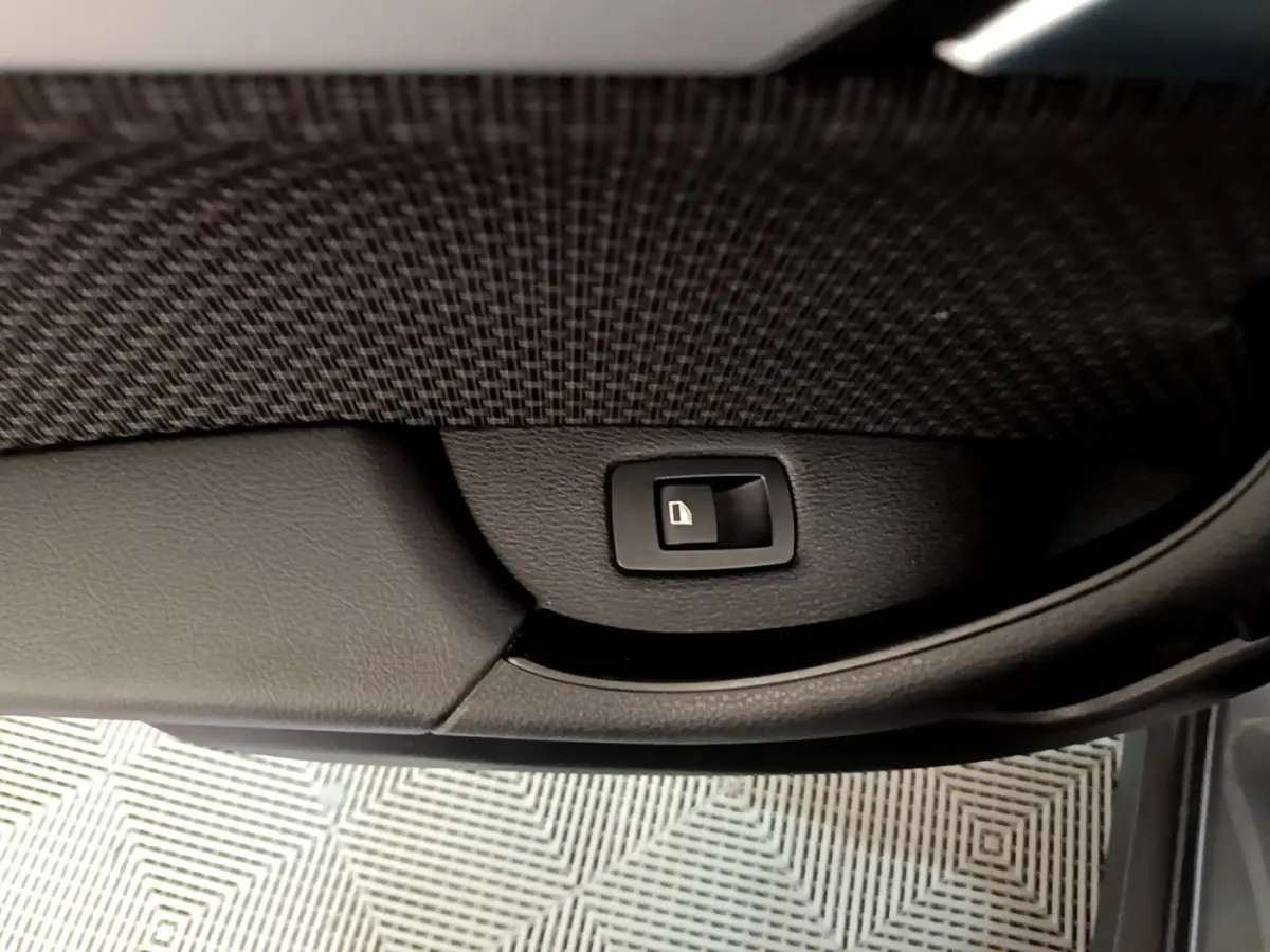 Bouton de verrouillage des portes sur la garniture intérieure noire d'une BMW X2 xDrive25e vue côté porte ouverte.
