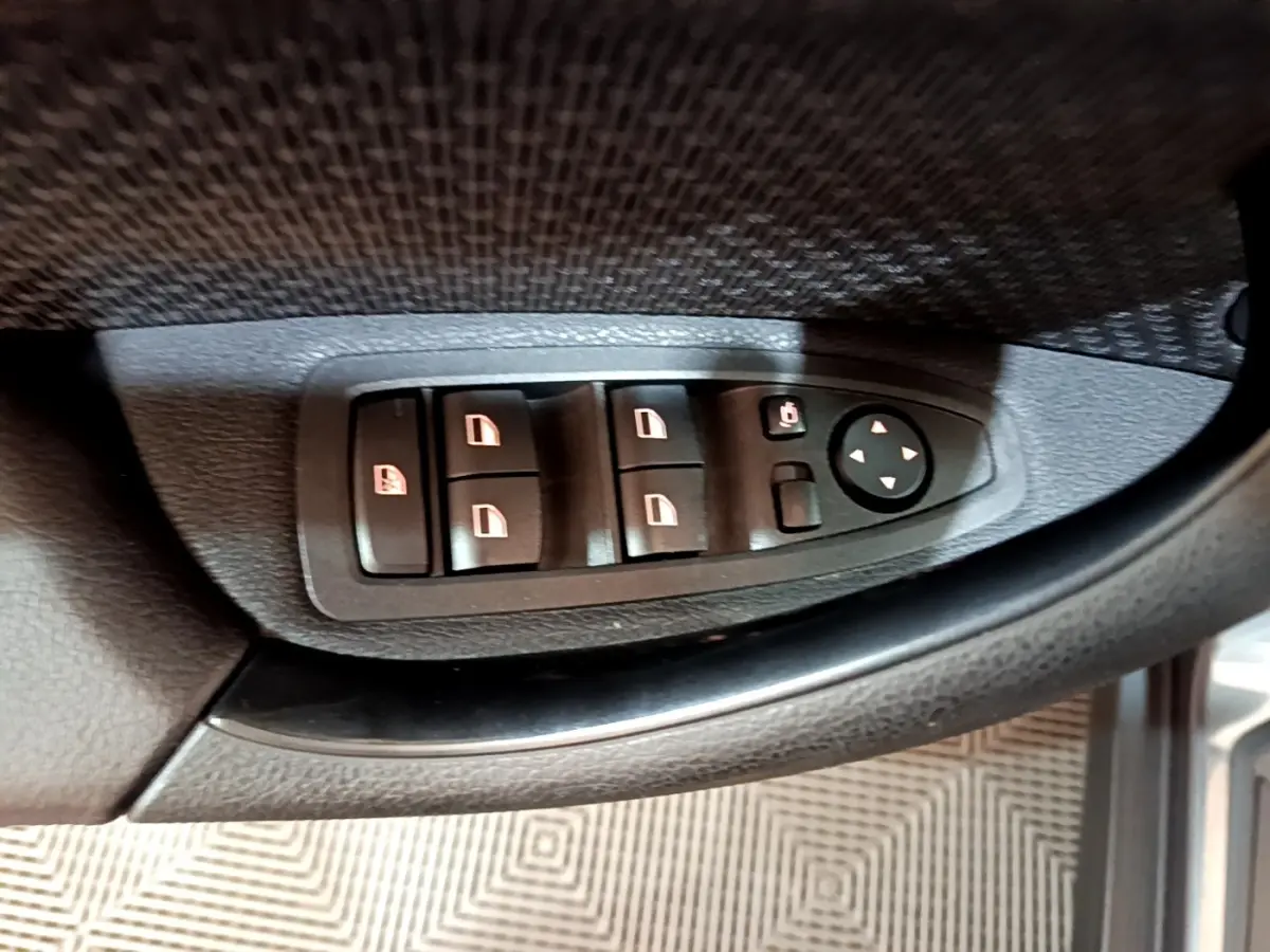 Gros plan sur les commandes de lève-vitres et rétroviseurs côté conducteur d'une BMW X2 hybride rechargeable 2020.