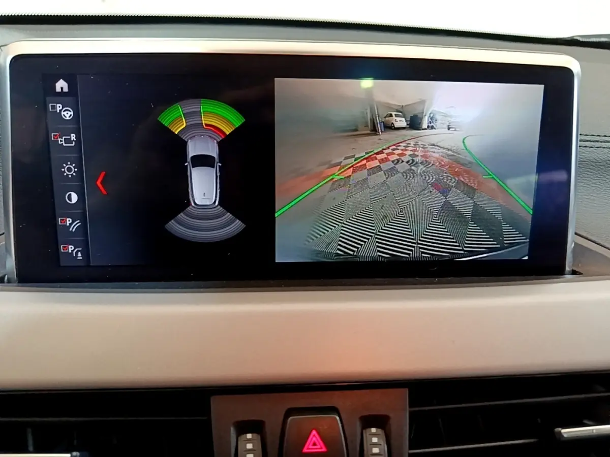 Écran tactile intérieur montrant la caméra de recul et les capteurs de stationnement du BMW X2 hybride rechargeable.