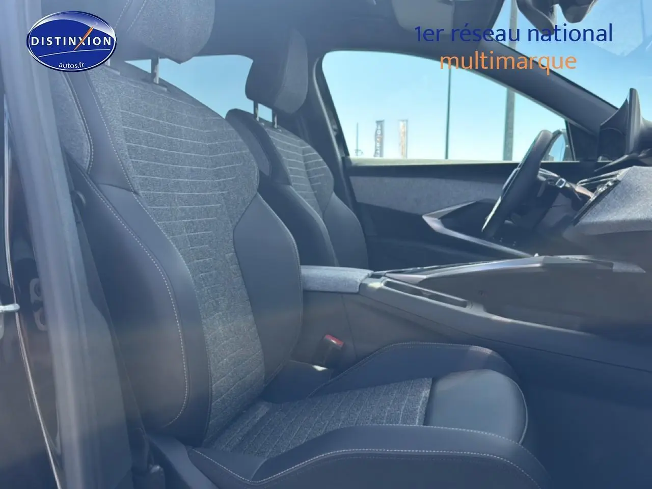 Vue intérieure côté gauche du Peugeot 5008 Hybrid 145 allure 2025, sièges tissu gris et cuir noir avec accoudoir central.