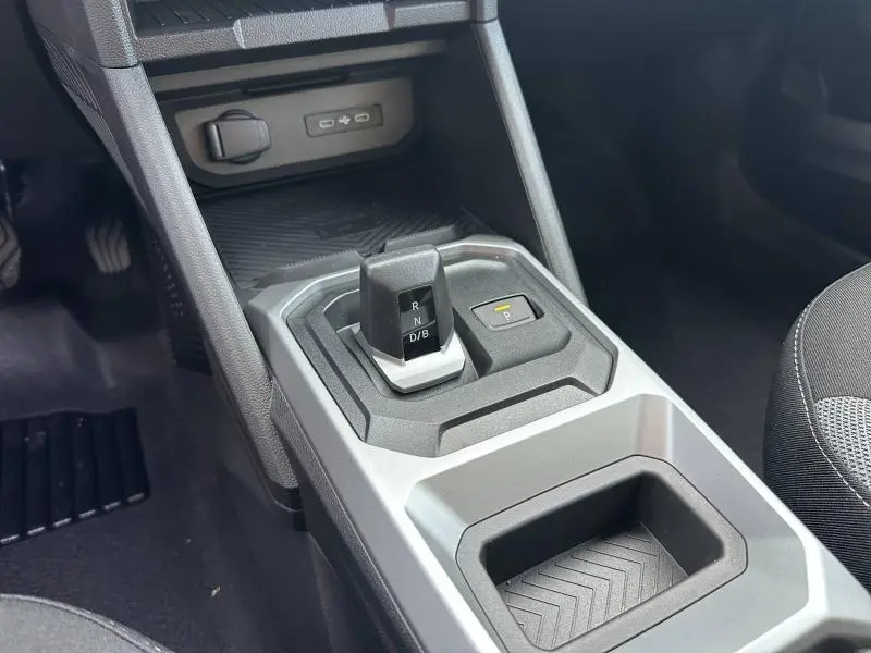 Gros plan sur la console centrale du Dacia Duster 1.8 hybrid 155ch Journey 2025, boîte auto, avec levier de vitesses et rangement.