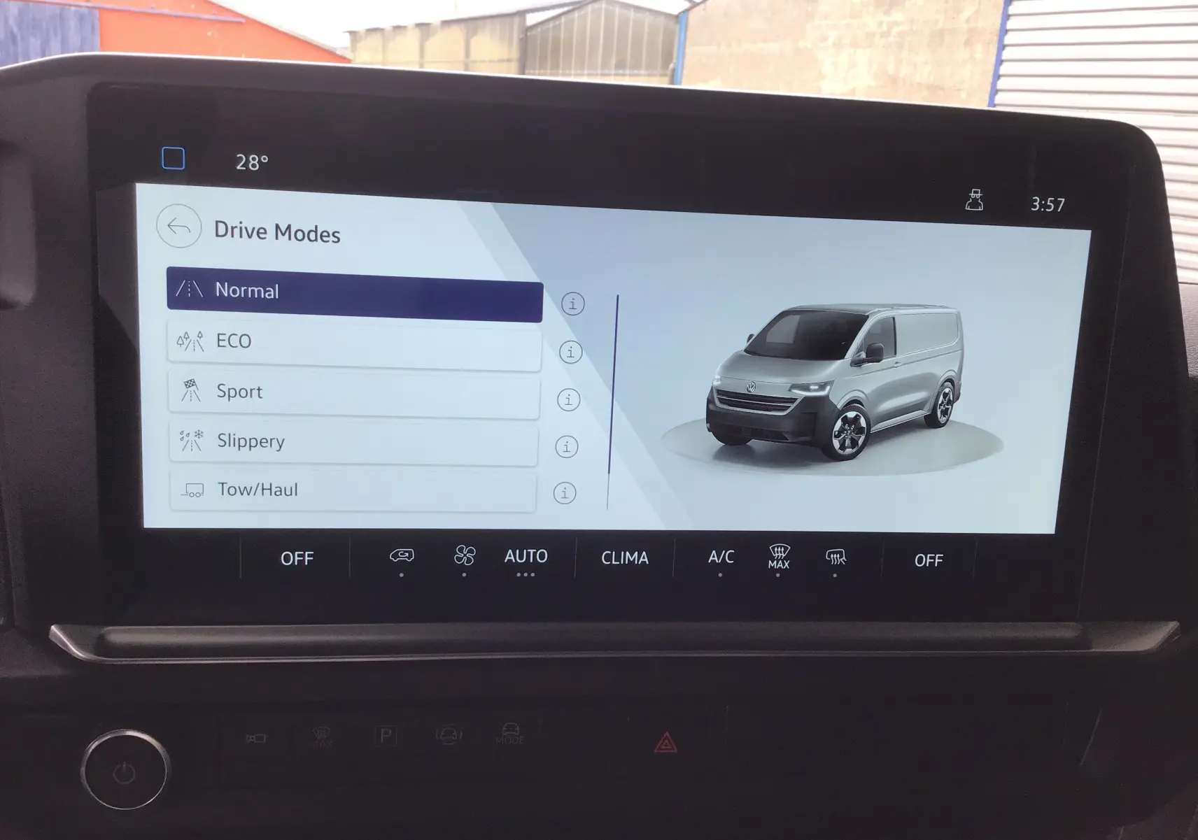Écran tactile intérieur affichant les modes de conduite avec une image 3D du Volkswagen Transporter T7 gris stone de profil avant droit.