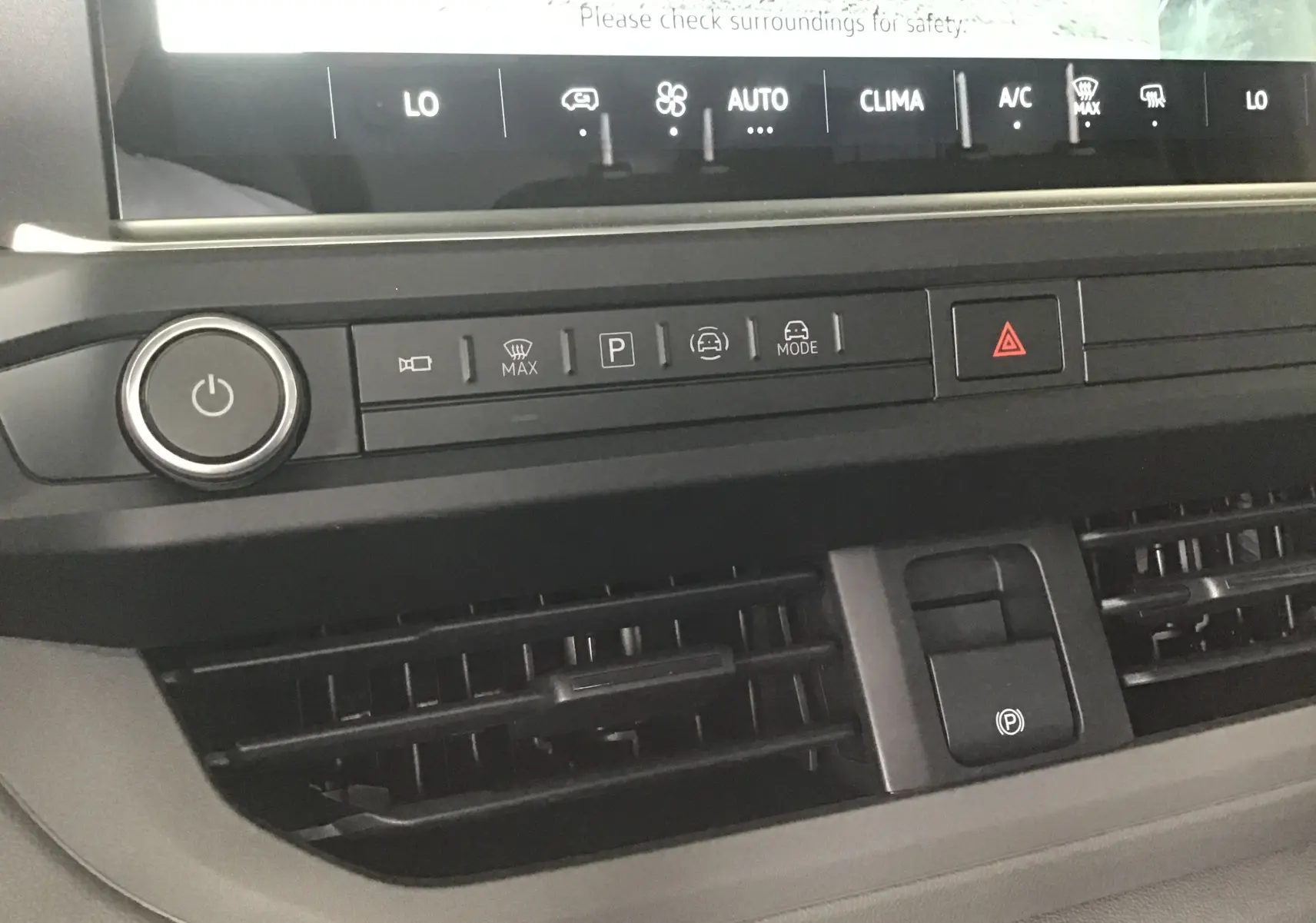 Détail du tableau de bord noir du Volkswagen Transporter T7 avec commandes climatisation et bouton de démarrage.