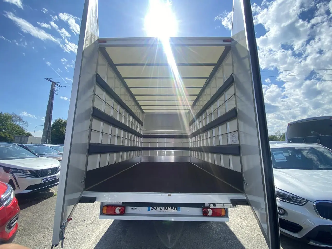 Vue arrière du Nissan Interstar blanc 2022 avec portes ouvertes montrant l'espace de chargement grand volume vide.