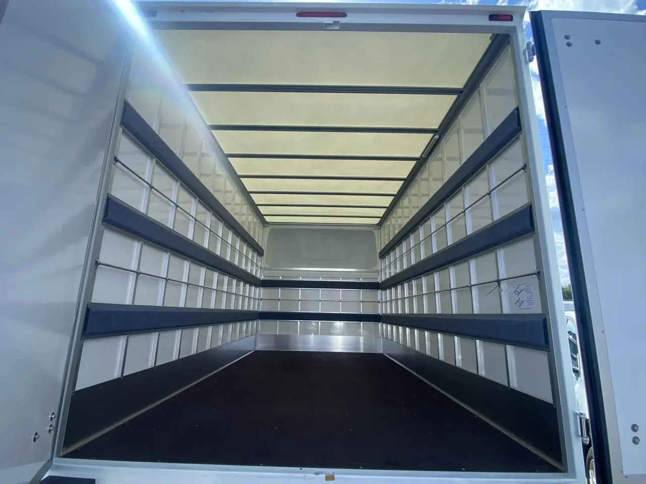 Vue intérieure arrière du grand volume de chargement blanc du Nissan Interstar Acenta 2022 avec capucine et parois renforcées.