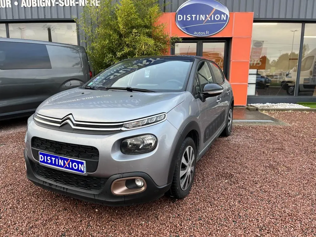 Citroën C3 gris foncé vue 3/4 avant droit avec toit noir et détails noirs autour des phares et rétroviseurs.