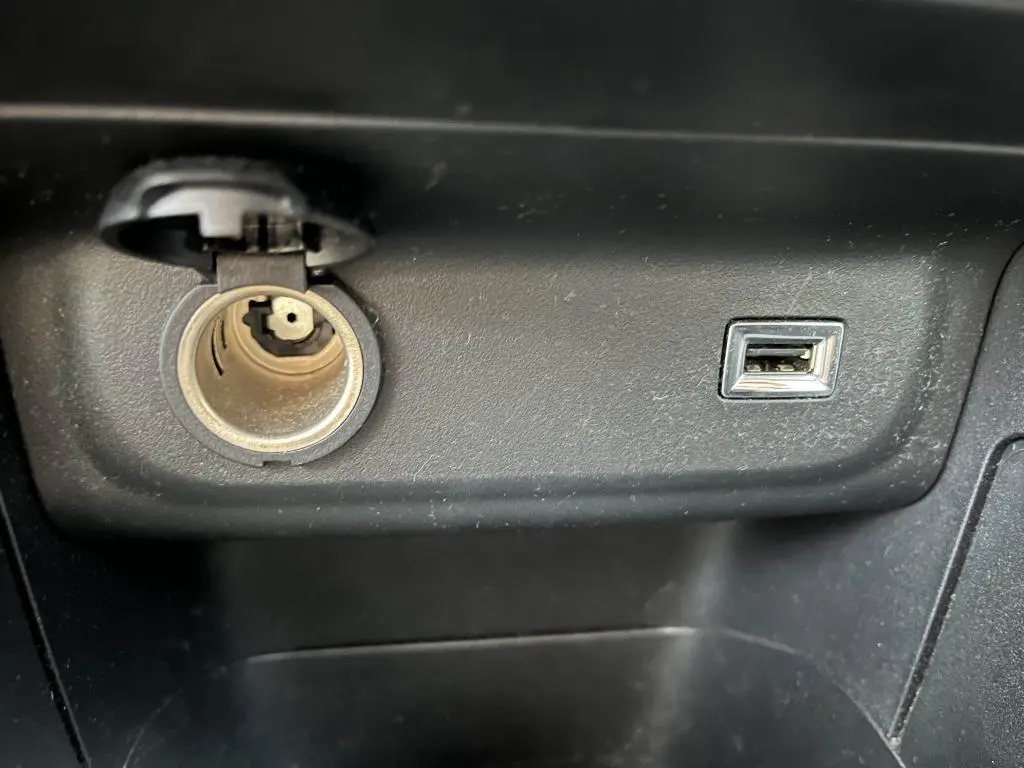Prise allume-cigare et port USB intégrés dans la console centrale noire d'une Citroën C3 2019 gris foncé Origins.