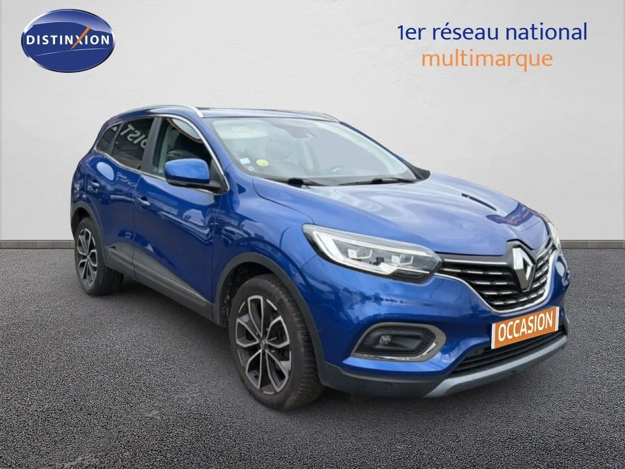 Renault Kadjar bleu Iron en 3/4 avant droit, SUV compact avec jantes alliage et calandre chromée.