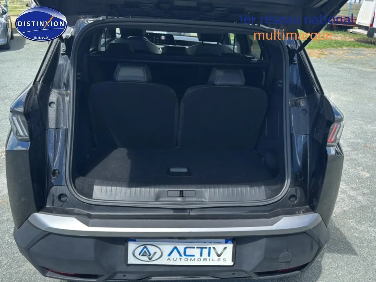 Vue arrière ouverte du Peugeot 5008 Hybrid 145 allure e-dcs6 noir, montrant le coffre et les sièges rabattables.