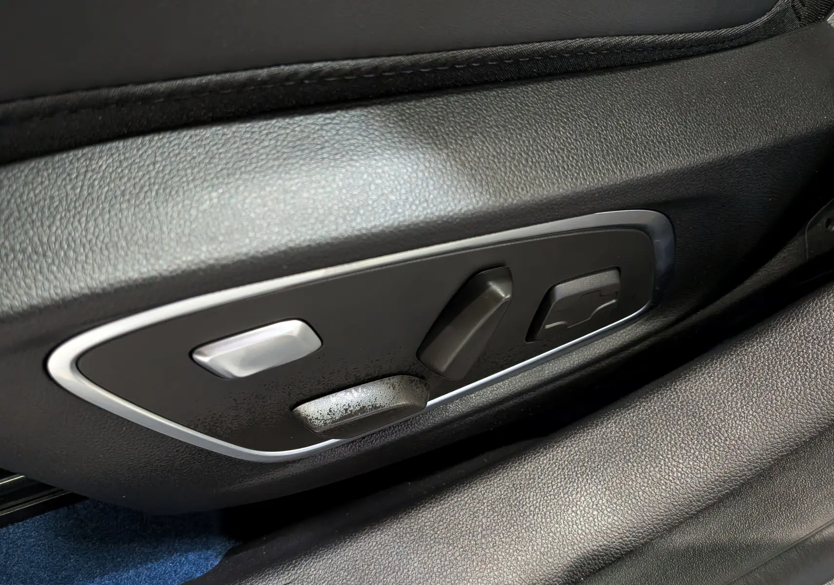 Gros plan sur les commandes de réglage électrique du siège en cuir noir du Renault Rafale hyper hybrid gris Schiste.