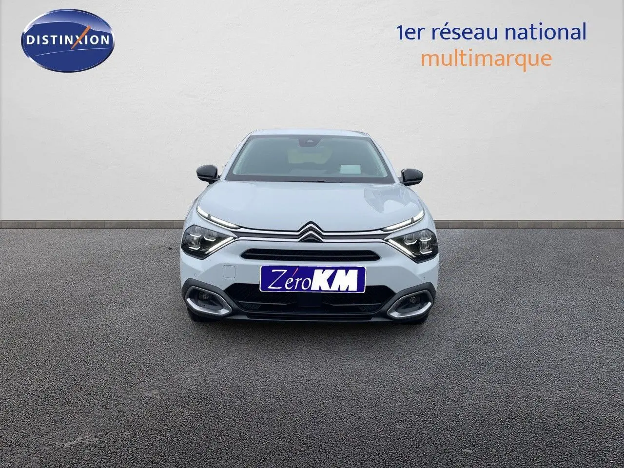 Vue frontale d'une Citroën C4 blanche métal 2024 avec phares LED et calandre distinctive sur fond neutre.