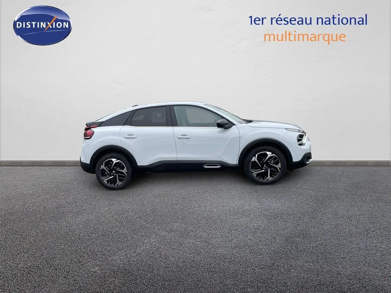 Profil droit d'une Citroën C4 blanche métal 2024 avec jantes noires et toit noir contrasté sur fond neutre.