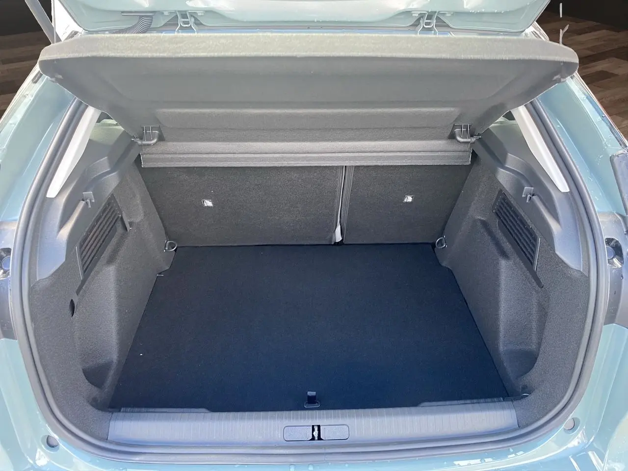 Coffre ouvert de la Citroën C4 Manhattan Green avec intérieur noir, vue arrière montrant l’espace de chargement vide.