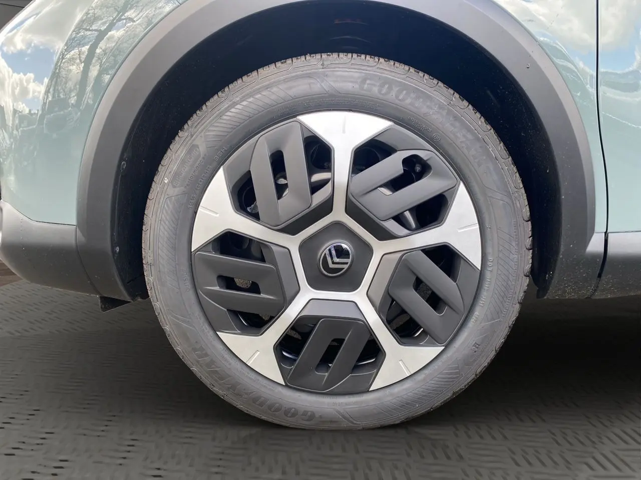 Gros plan sur la roue avant gauche de la Citroën C4 Manhattan Green avec jante Aerotech bicolore et pneu Goodyear.