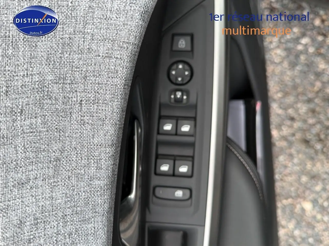 Détail des commandes des vitres et rétroviseurs côté conducteur du Peugeot 5008 noir, vue rapprochée verticale.