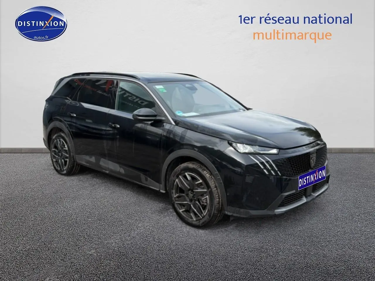Peugeot 5008 Hybrid noir en 3/4 avant droit, avec jantes alu et calandre distinctive moderne.