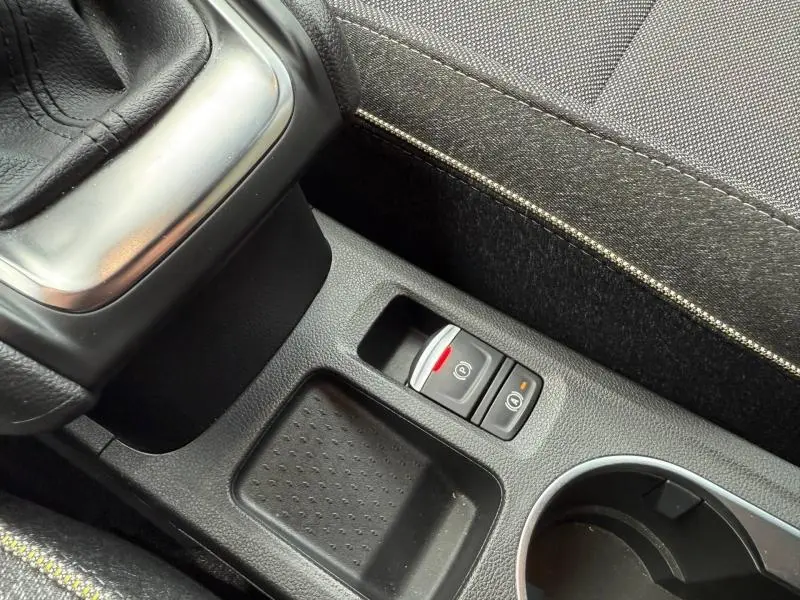 Gros plan sur la console centrale du Renault Captur 2025, montrant le frein à main électronique et les boutons de contrôle.