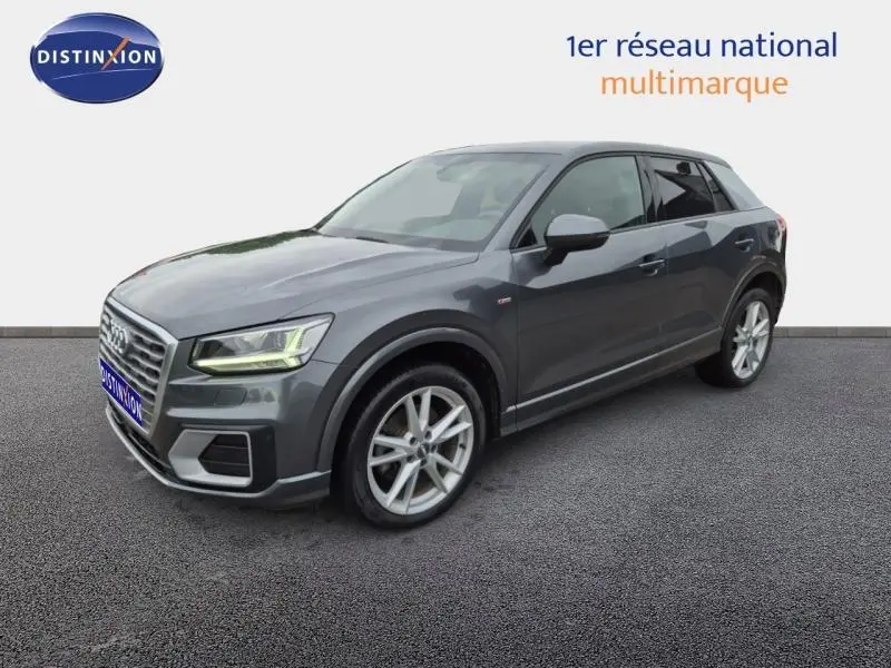 Audi Q2 gris Manhattan vue 3/4 avant droit, avec jantes alu et feux LED allumés.