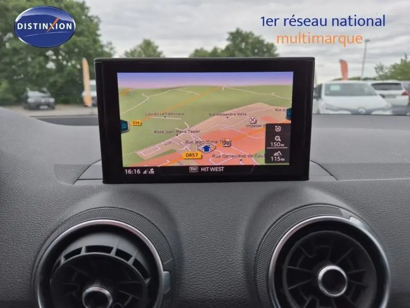 Écran GPS couleur du tableau de bord de l'Audi Q2 gris Manhattan, avec aérateurs ronds en avant-plan.