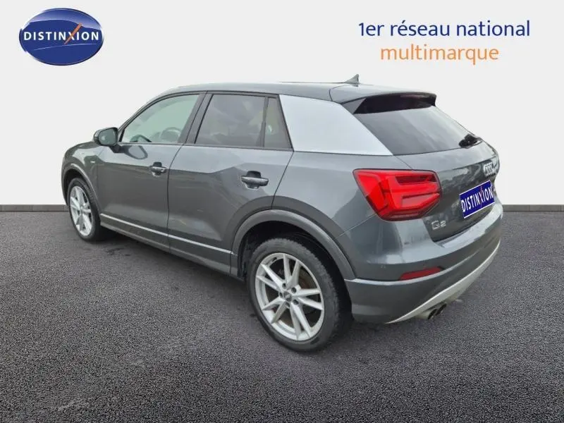 Audi Q2 gris Manhattan vue 3/4 arrière droit, avec jantes alu et feux arrière LED distinctifs.