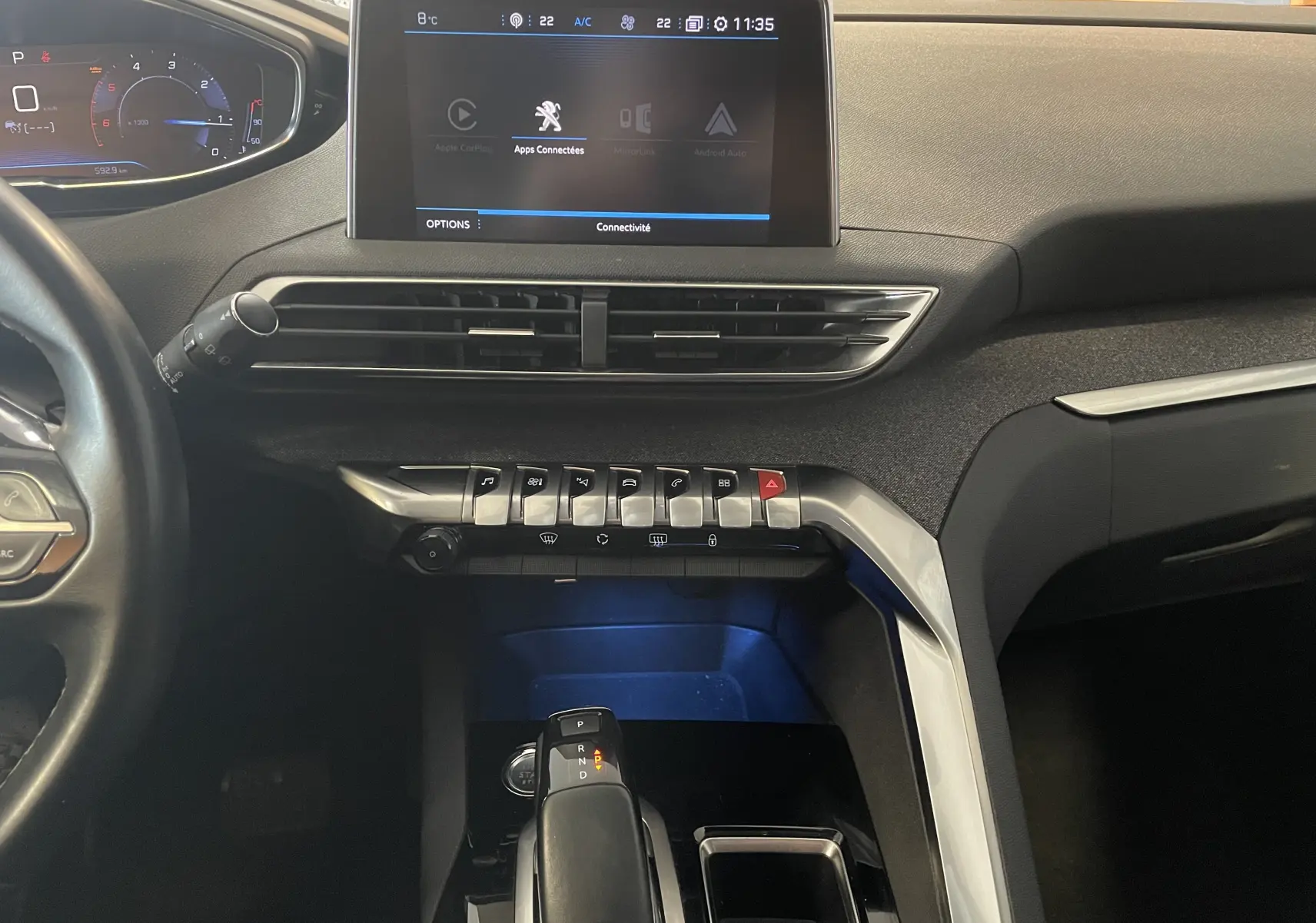 Vue intérieure du tableau de bord du Peugeot 5008 blanc nacré, mettant en valeur l'écran tactile central et la console de commande.
