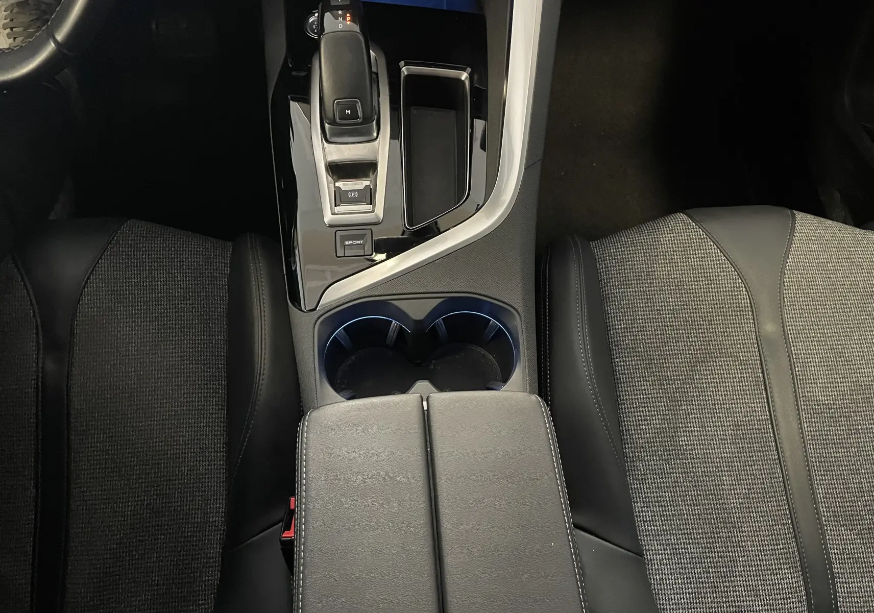 Vue plongeante sur la console centrale noire et les sièges tissu et cuir du Peugeot 5008 blanc nacré 2019.
