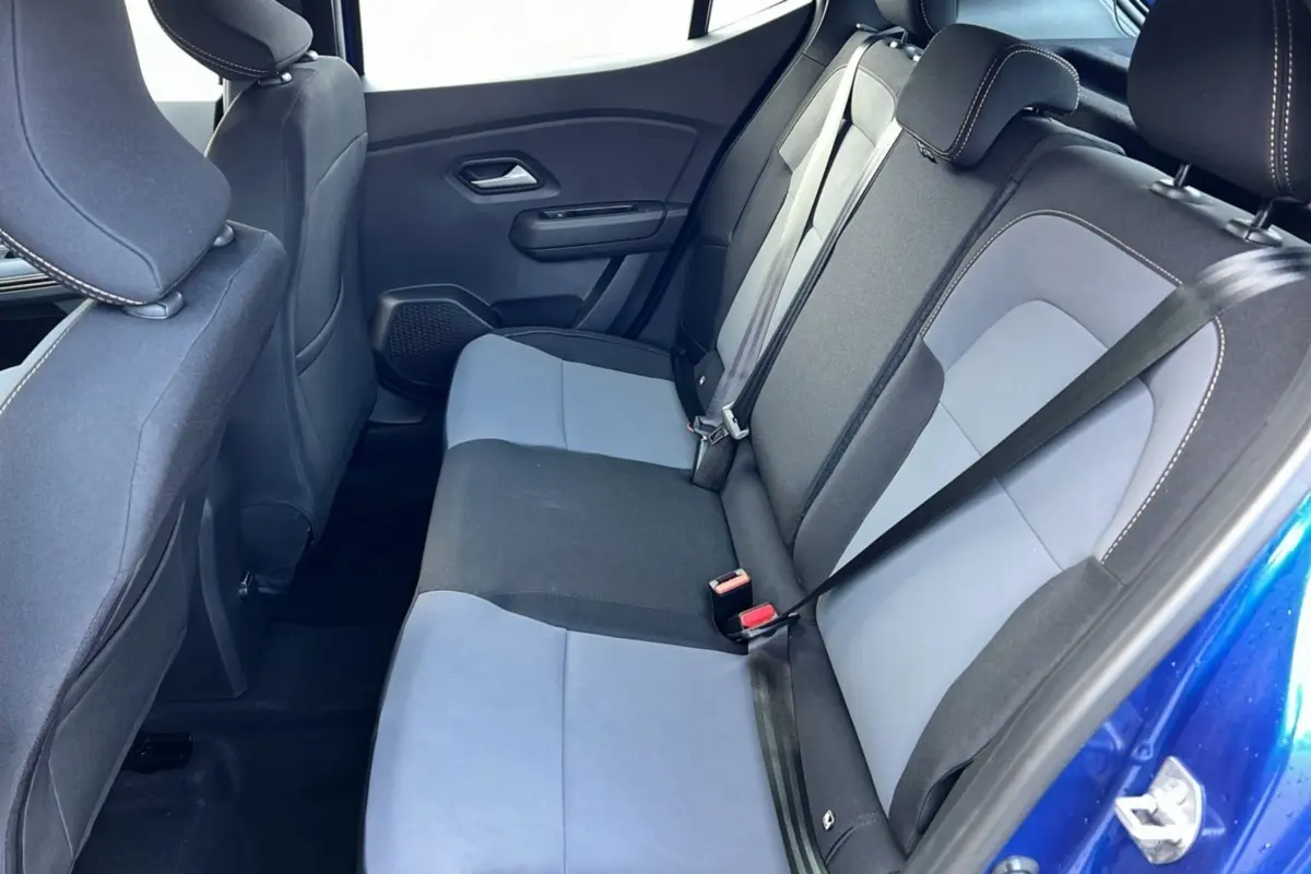 Vue intérieure arrière côté droit de la DACIA SANDERO Stepway 2024 en bleu iron avec sièges bicolores gris et noir.