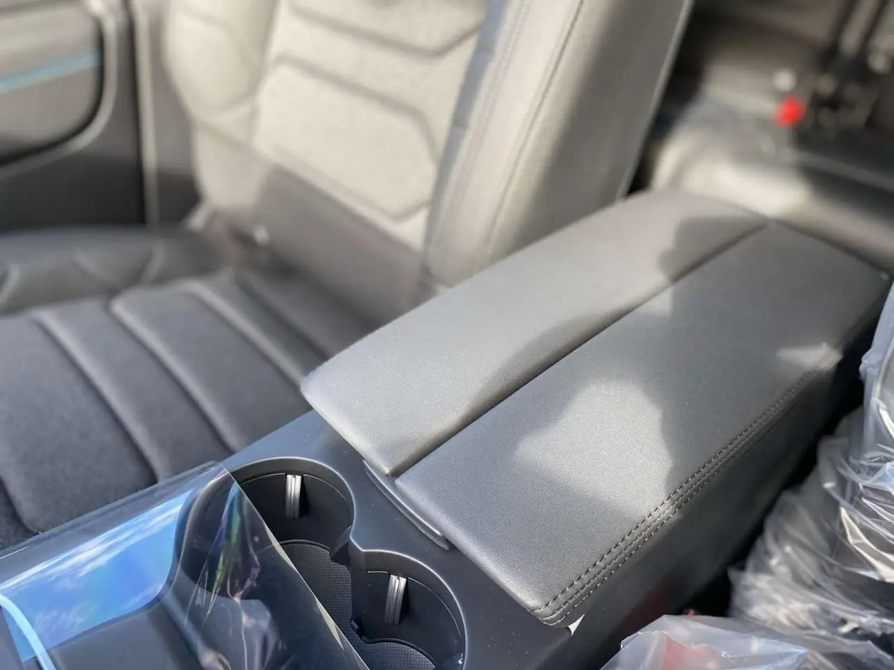 Gros plan sur l'accoudoir central arrière en cuir gris avec porte-gobelets du Citroën C5 Aircross 2025.