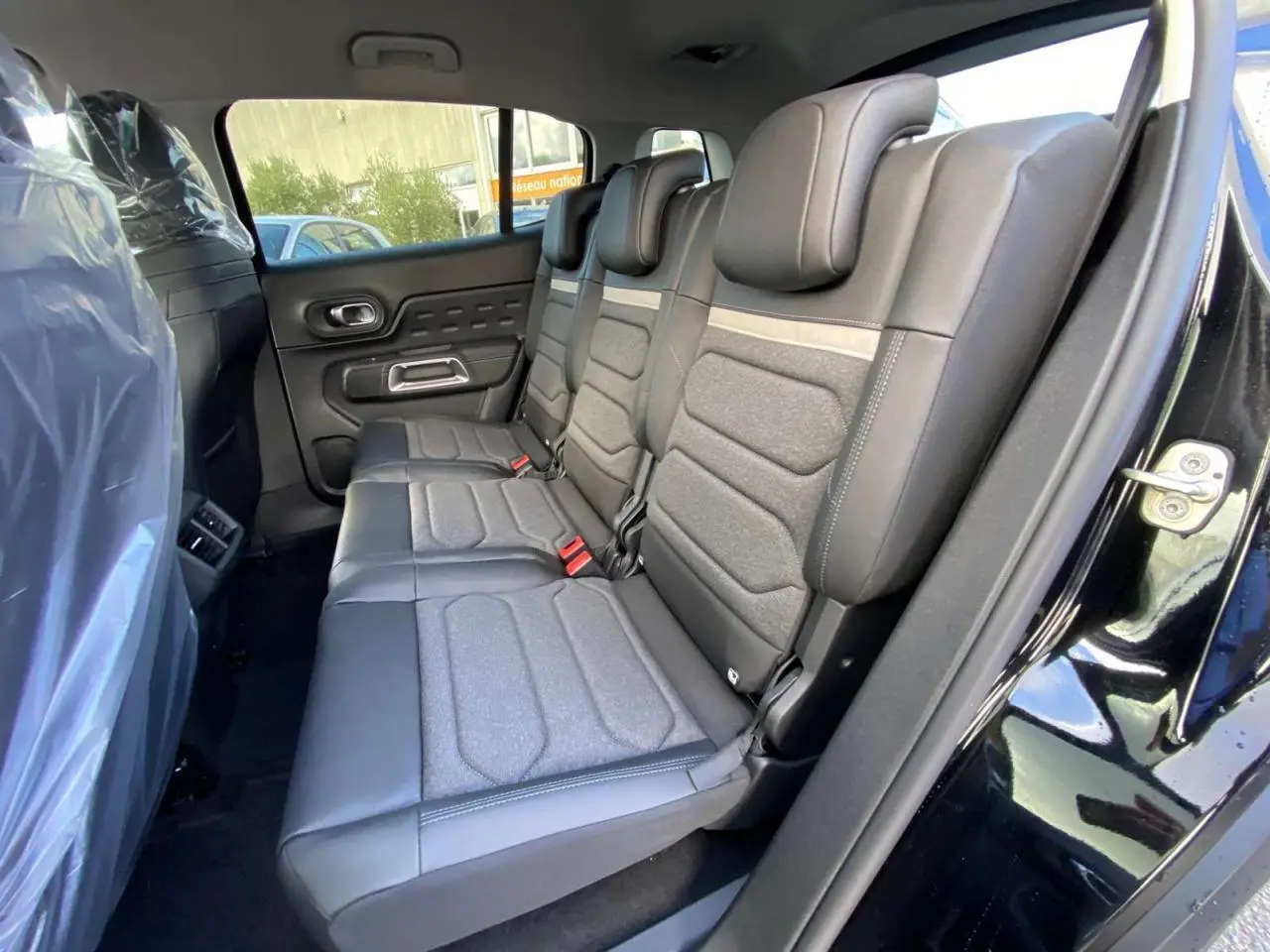 Vue latérale droite des sièges arrière en cuir et tissu gris du Citroën C5 Aircross noir perla 2025, porte ouverte.