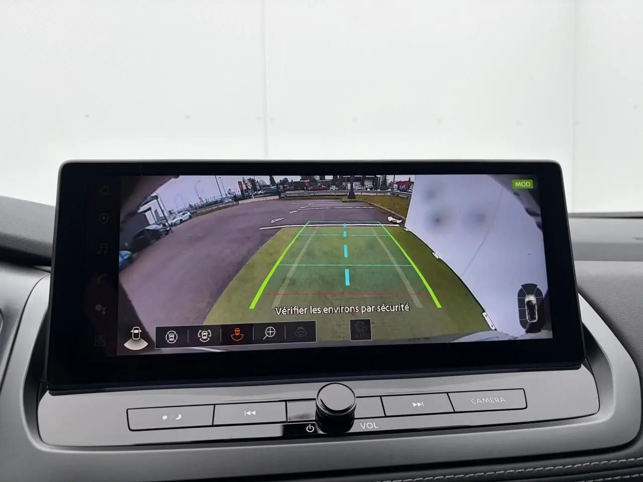 Écran central affichant la caméra de recul avec lignes de guidage dans un Nissan Qashqai gris foncé.