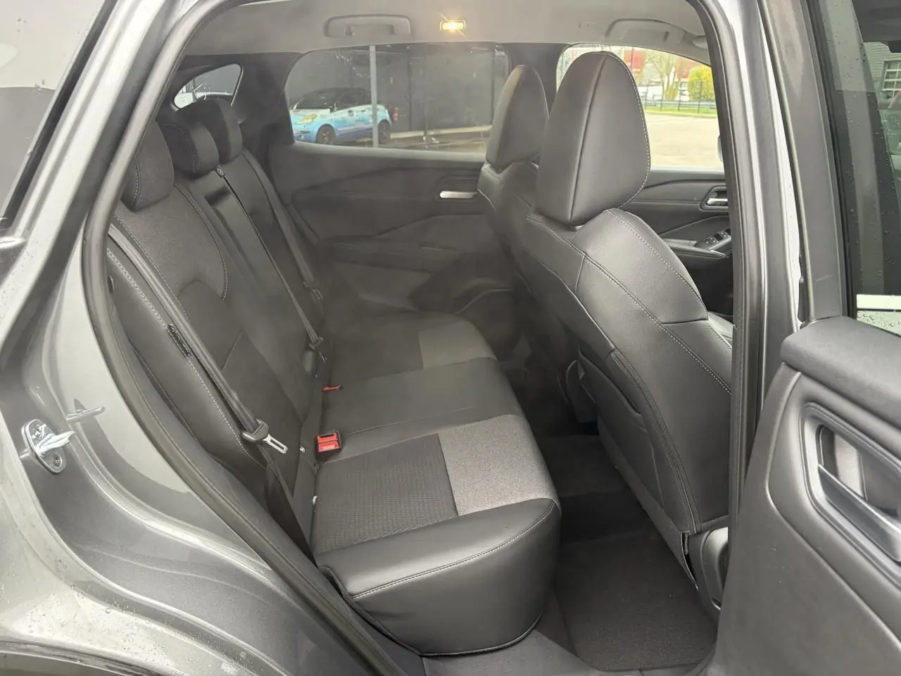 Vue intérieure côté gauche sur la banquette arrière mixte tissu et TEP noire du Nissan Qashqai III gris foncé métallisé.