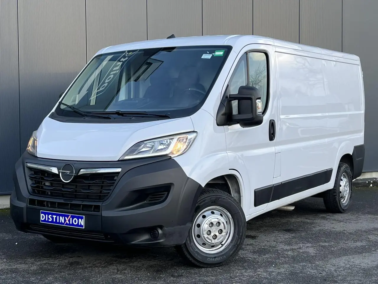 Vue 3/4 avant droit d’un Opel Movano Fourgon blanc avec pare-chocs noirs et rétroviseurs électriques rabattables.