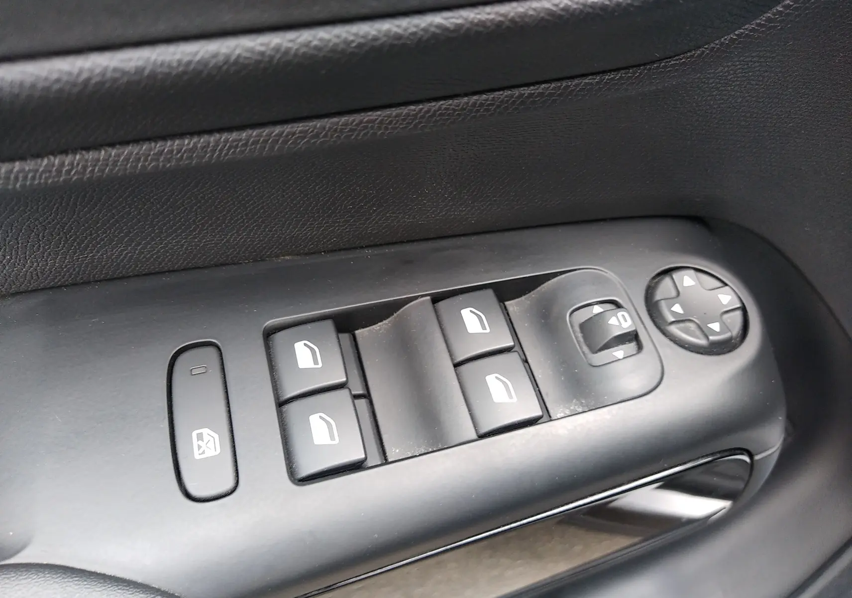 Gros plan sur les commandes de lève-vitres et réglage des rétroviseurs côté conducteur noir du Citroën C5 Aircross 2023.