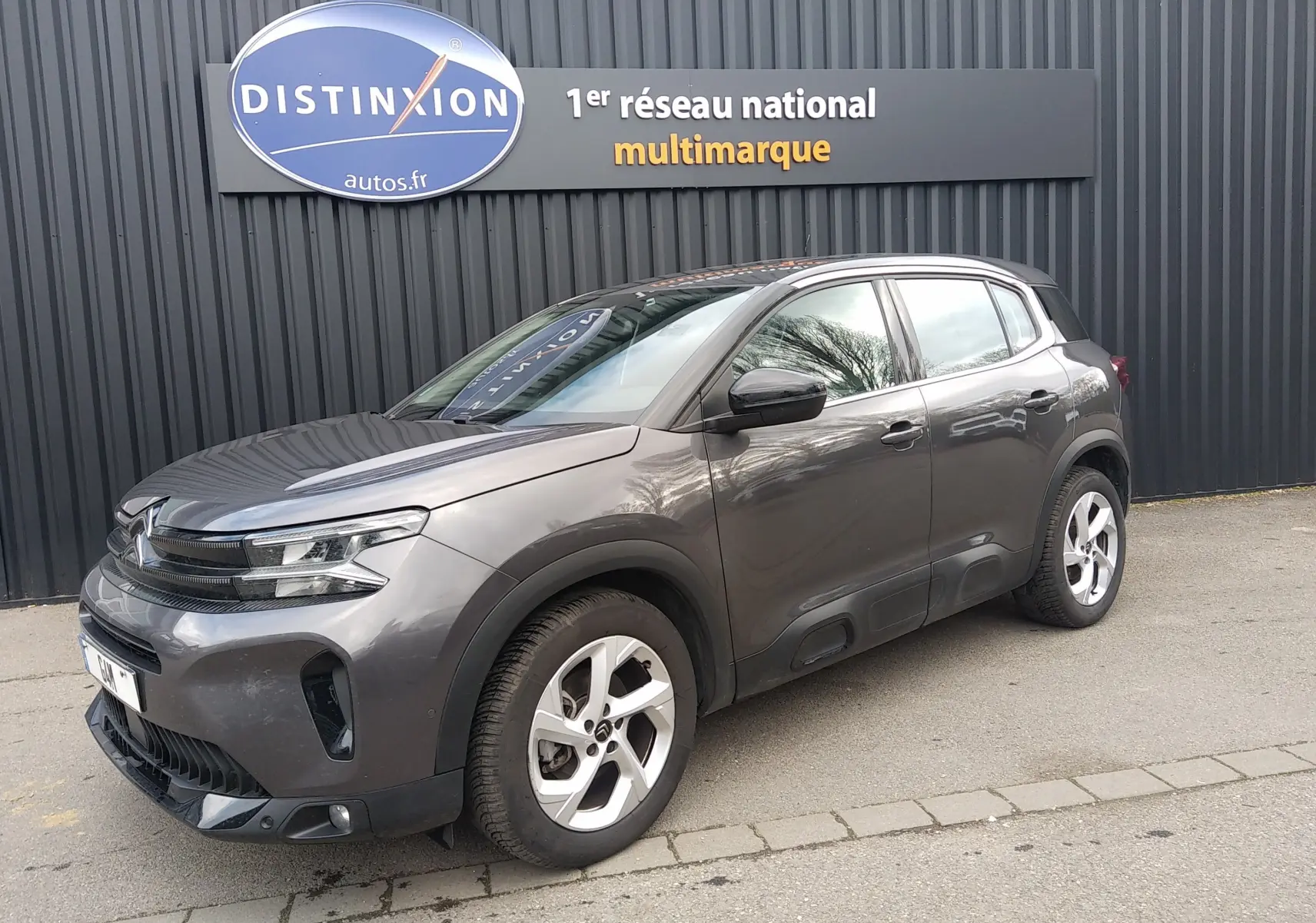 Citroën C5 Aircross gris métallisé vue 3/4 avant droit, avec jantes alliage et signature lumineuse LED.