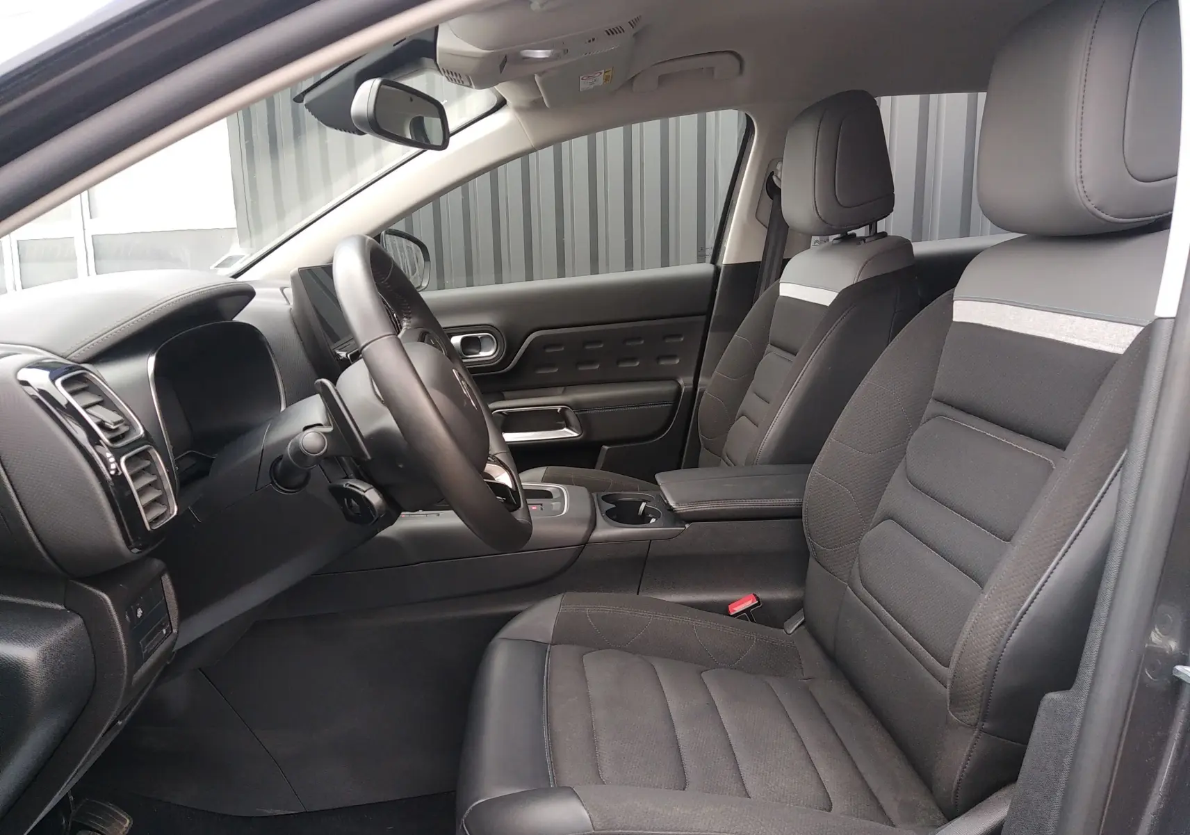 Vue intérieure côté gauche du poste de conduite du Citroën C5 Aircross 2023 avec sièges noirs et tableau de bord moderne.