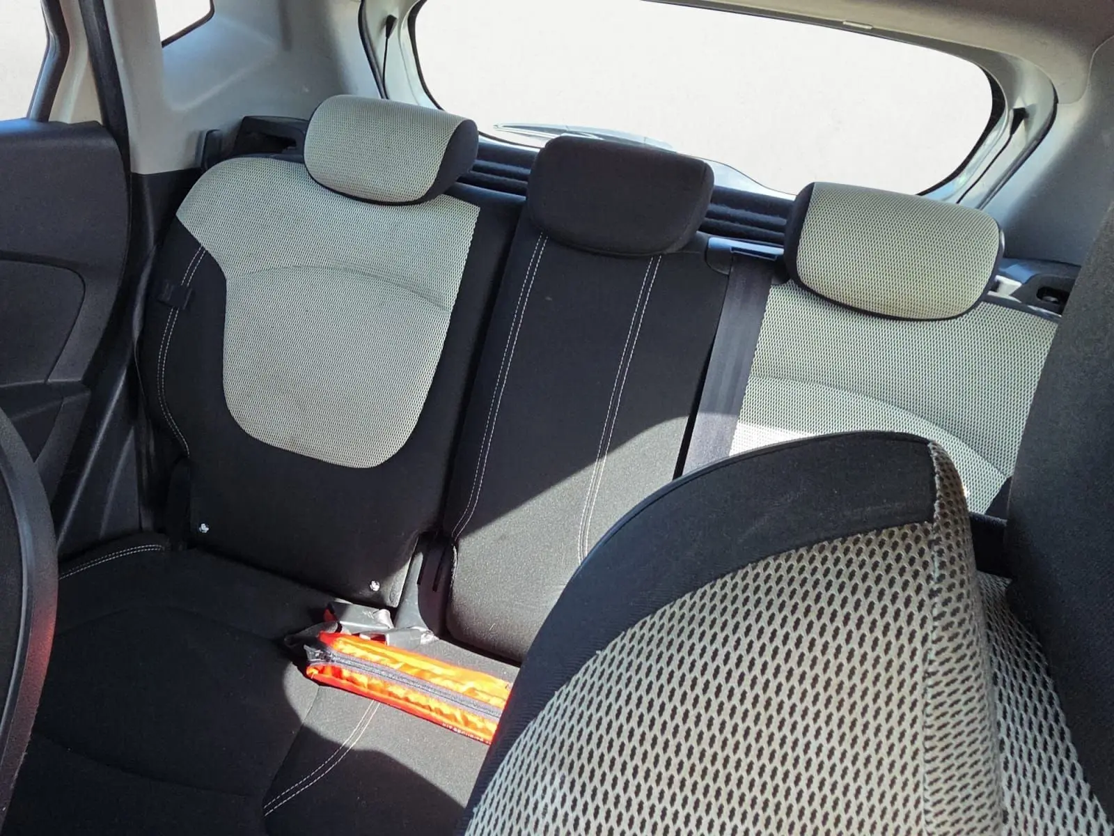 Vue intérieure arrière du Renault Captur 1.5 dCi 2018, sièges bicolores ivoire et noir avec appuie-têtes.