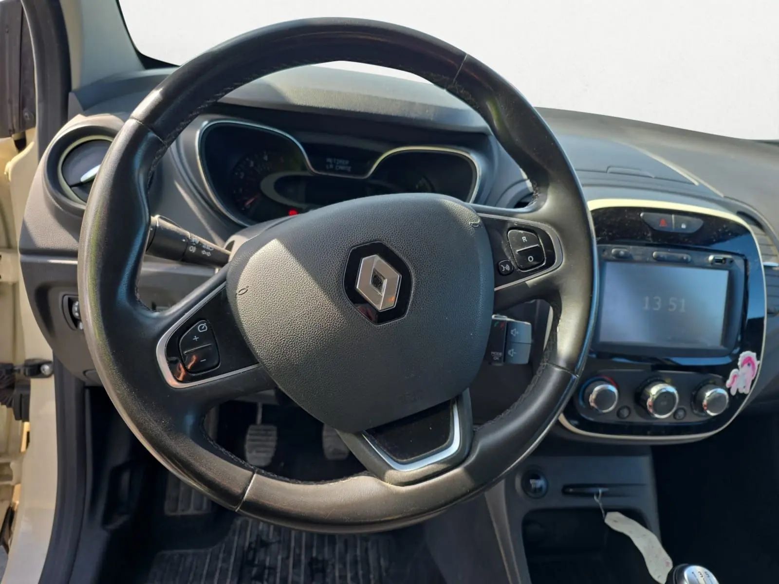 Vue rapprochée du volant en cuir noir et du tableau de bord du Renault Captur ivoire, version 2018 diesel.