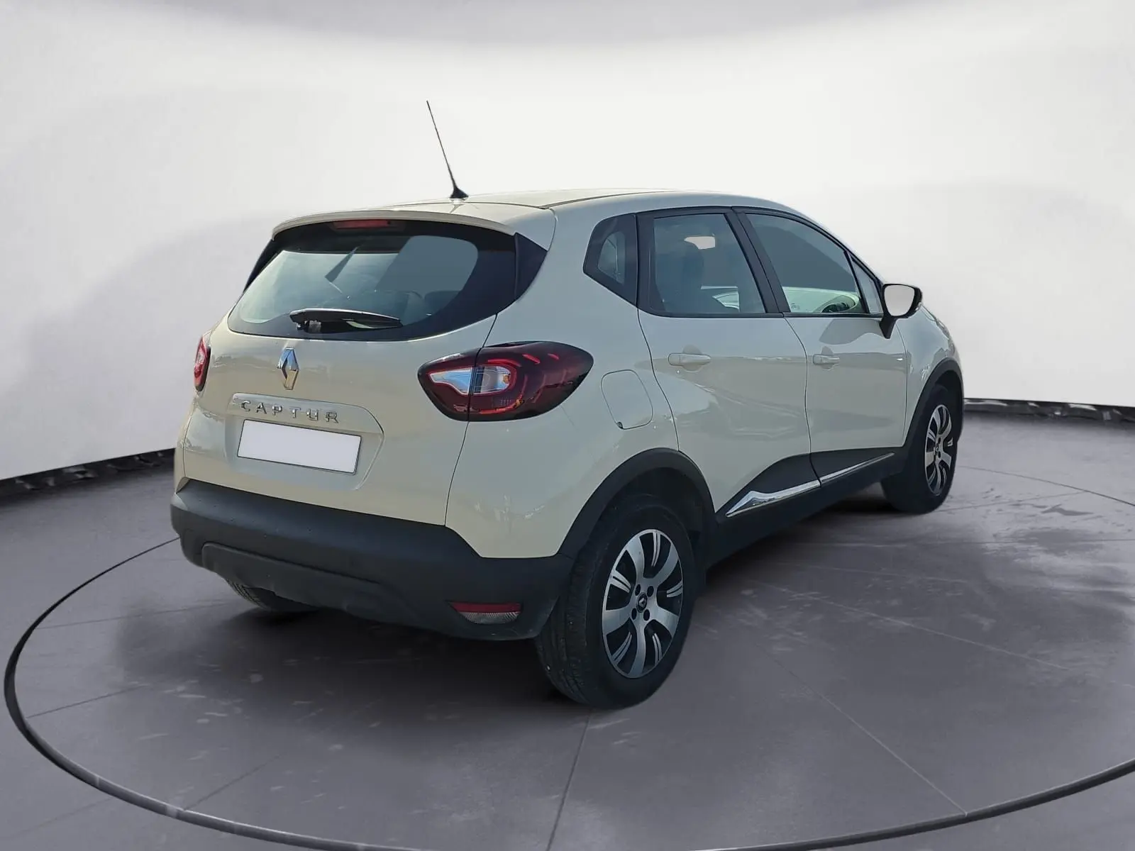 Renault Captur ivoire en 3/4 arrière droit, mettant en valeur ses feux arrière et ses jantes alliage noires.
